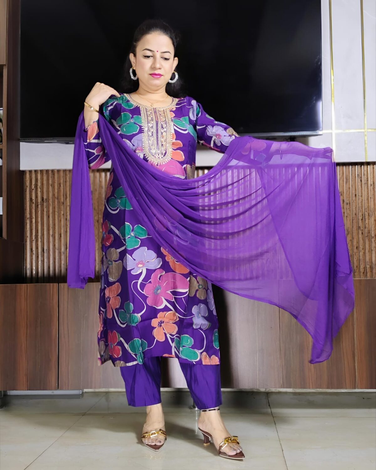 Woman wearing purple silk blend floral print suit with embroidered neckline and matching dupatta