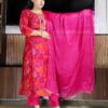 Woman wearing bright pink silk blend suit set with abstract multicolor print, embroidered neckline, and matching dupatta