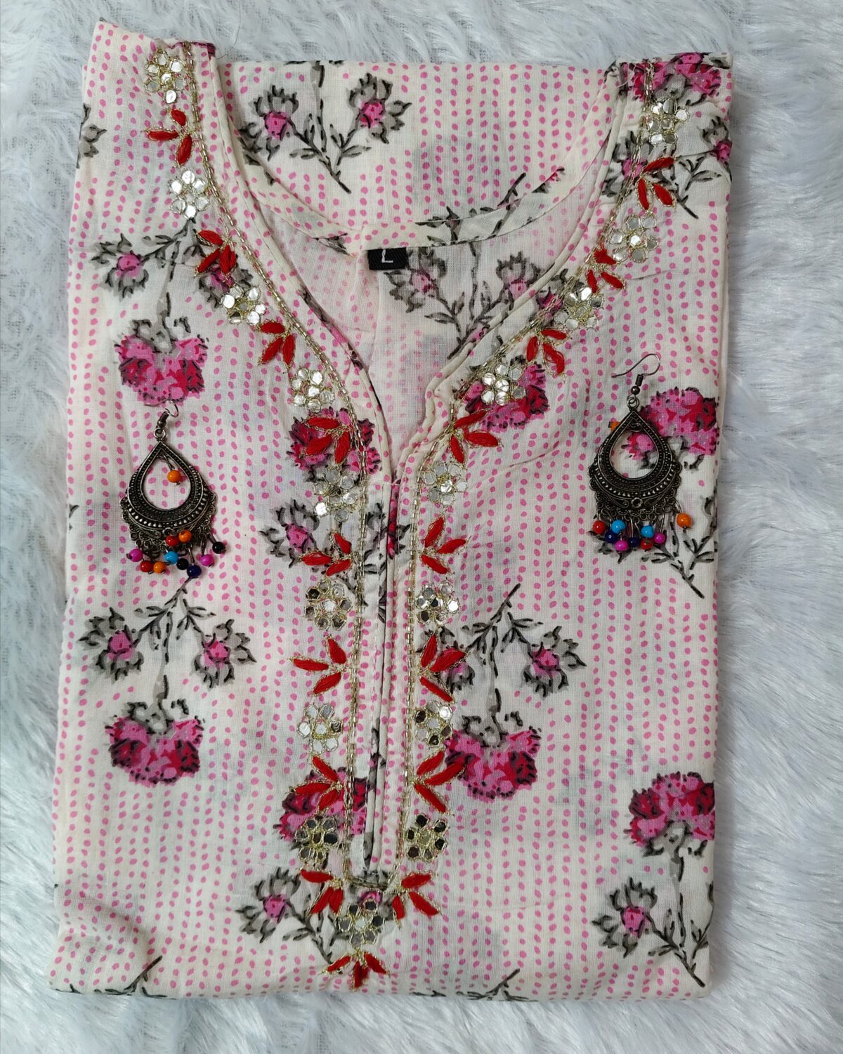 Woman wearing elegant white and pink floral Cambric Cotton suit set with kurta, printed pant, and dupatta – ethnic wear for women.