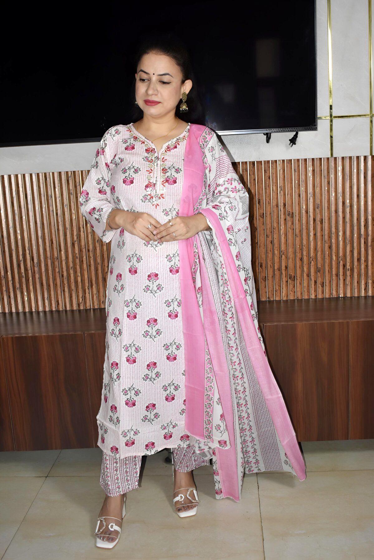 Woman wearing elegant white and pink floral Cambric Cotton suit set with kurta, printed pant, and dupatta – ethnic wear for women.