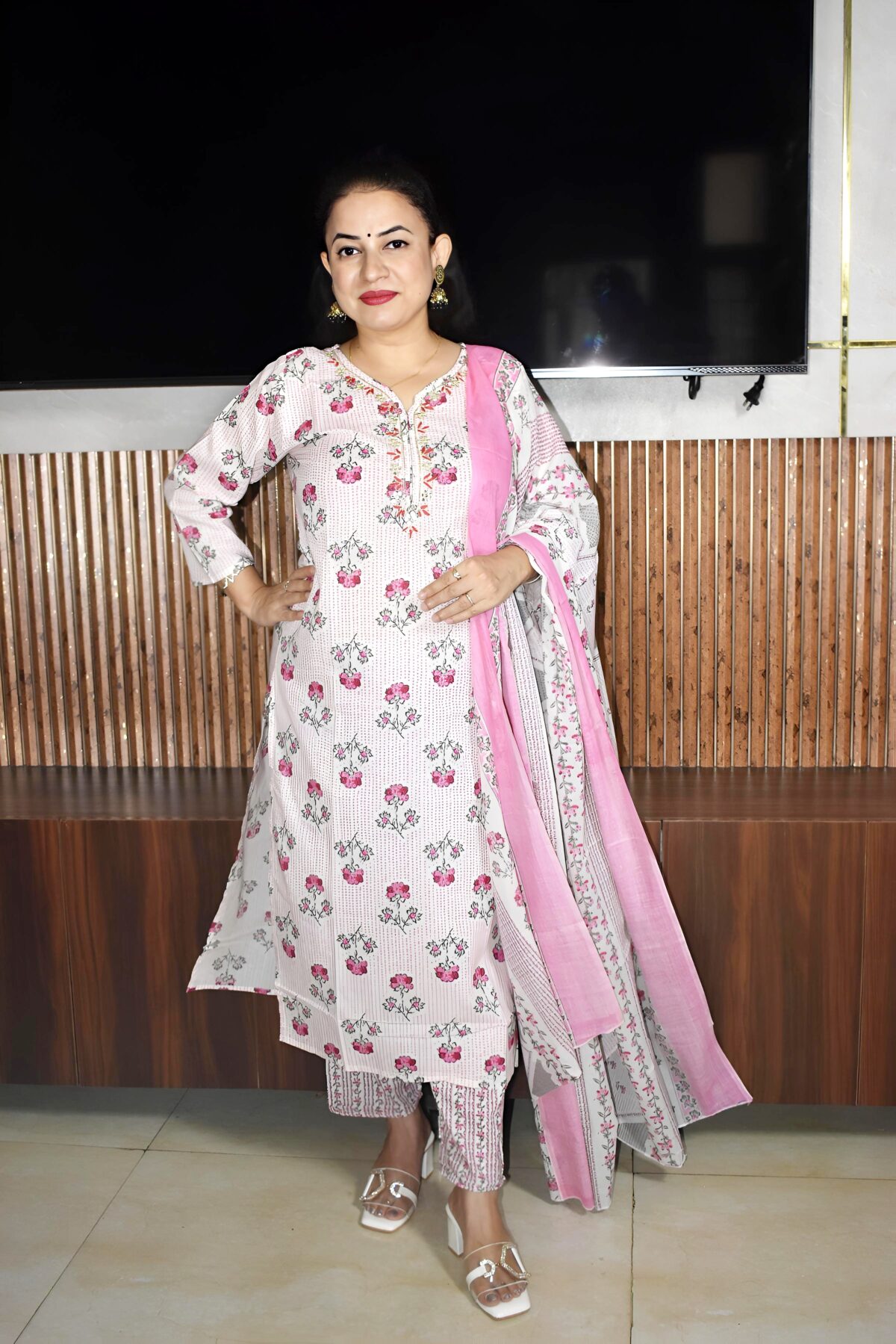 Woman wearing elegant white and pink floral Cambric Cotton suit set with kurta, printed pant, and dupatta – ethnic wear for women.