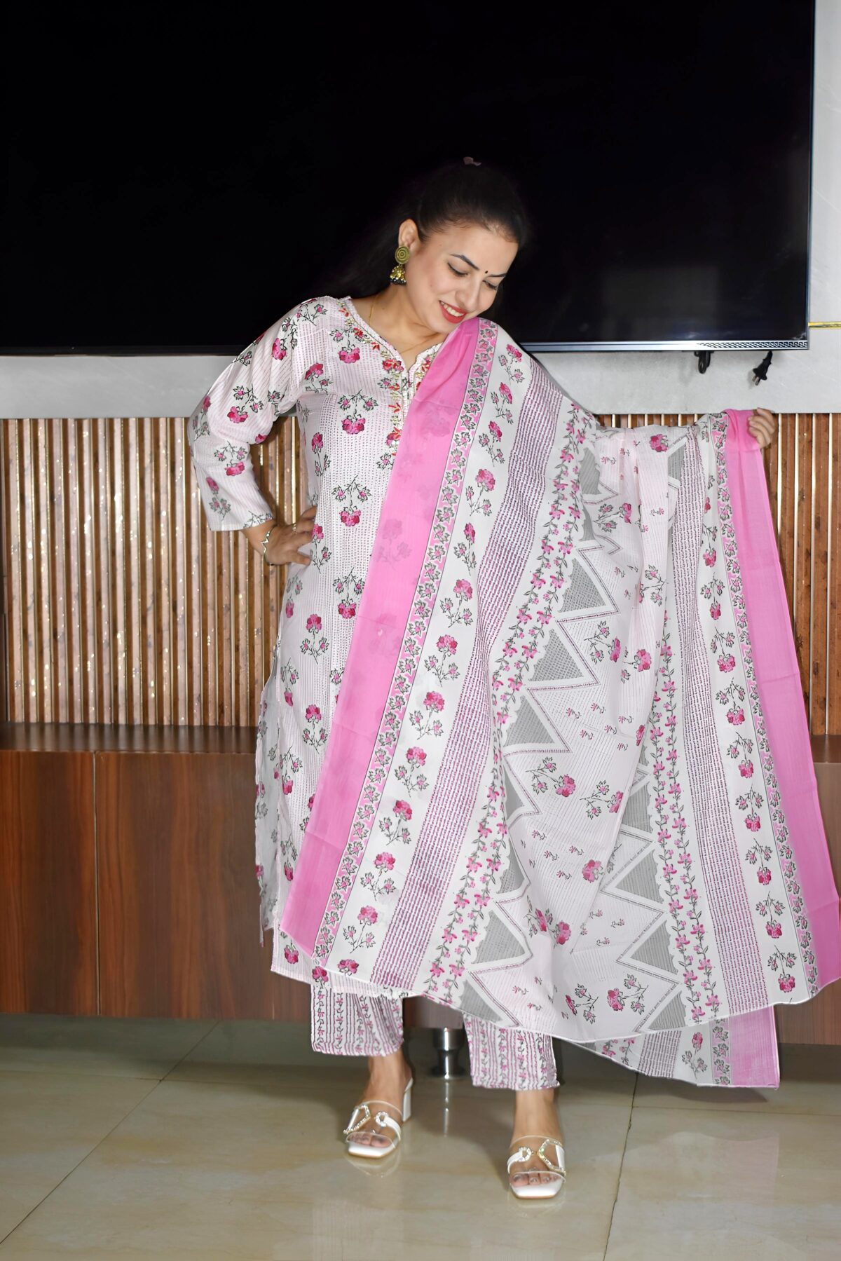 Woman wearing elegant white and pink floral Cambric Cotton suit set with kurta, printed pant, and dupatta – ethnic wear for women.