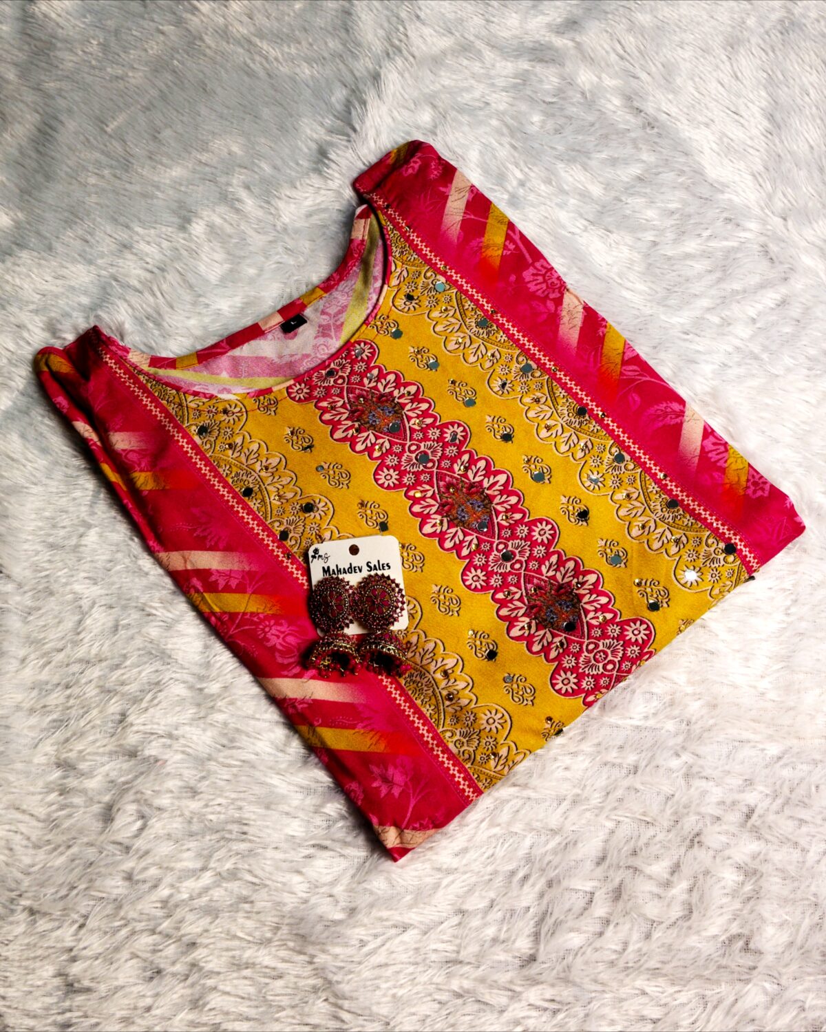 Woman wearing vibrant yellow and pink embroidered muslin suit set with floral motifs and matching printed dupatta – festive ethnic wear.