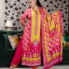 Woman wearing vibrant yellow and pink embroidered muslin suit set with floral motifs and matching printed dupatta – festive ethnic wear.