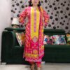 Woman wearing vibrant yellow and pink embroidered muslin suit set with floral motifs and matching printed dupatta – festive ethnic wear.