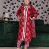 Woman wearing a premium rust handblock printed cotton suit set featuring lace-detailed V-neck kurta, printed pants, and matching dupatta.