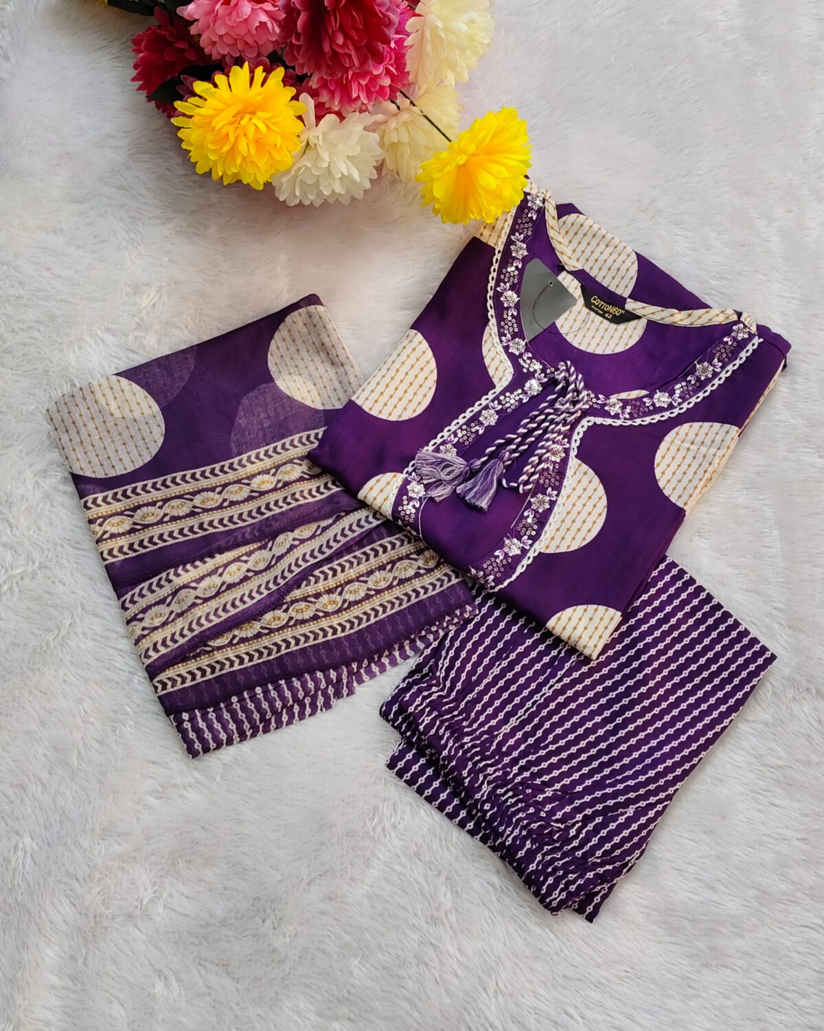 Woman wearing a premium cotton purple polka print suit set with matching pants and dupatta