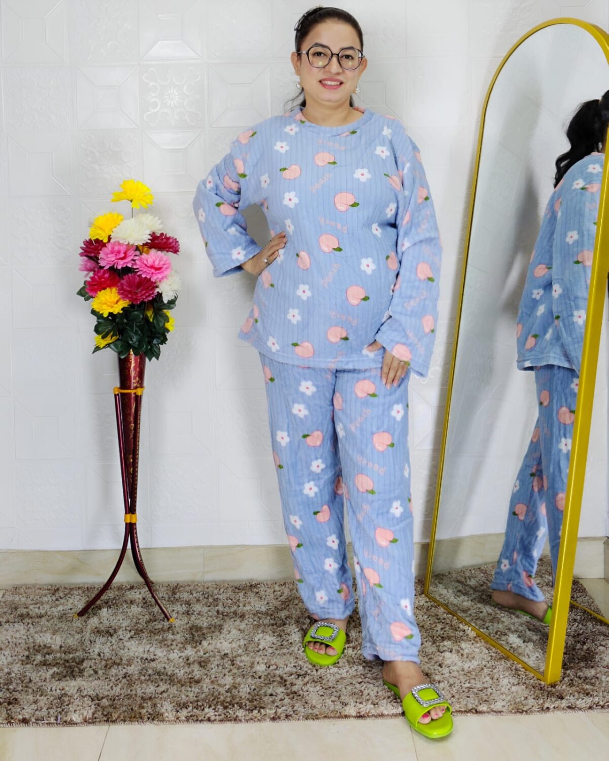 woman wearing blue printed winter fleece night suit with floral and fruit pattern