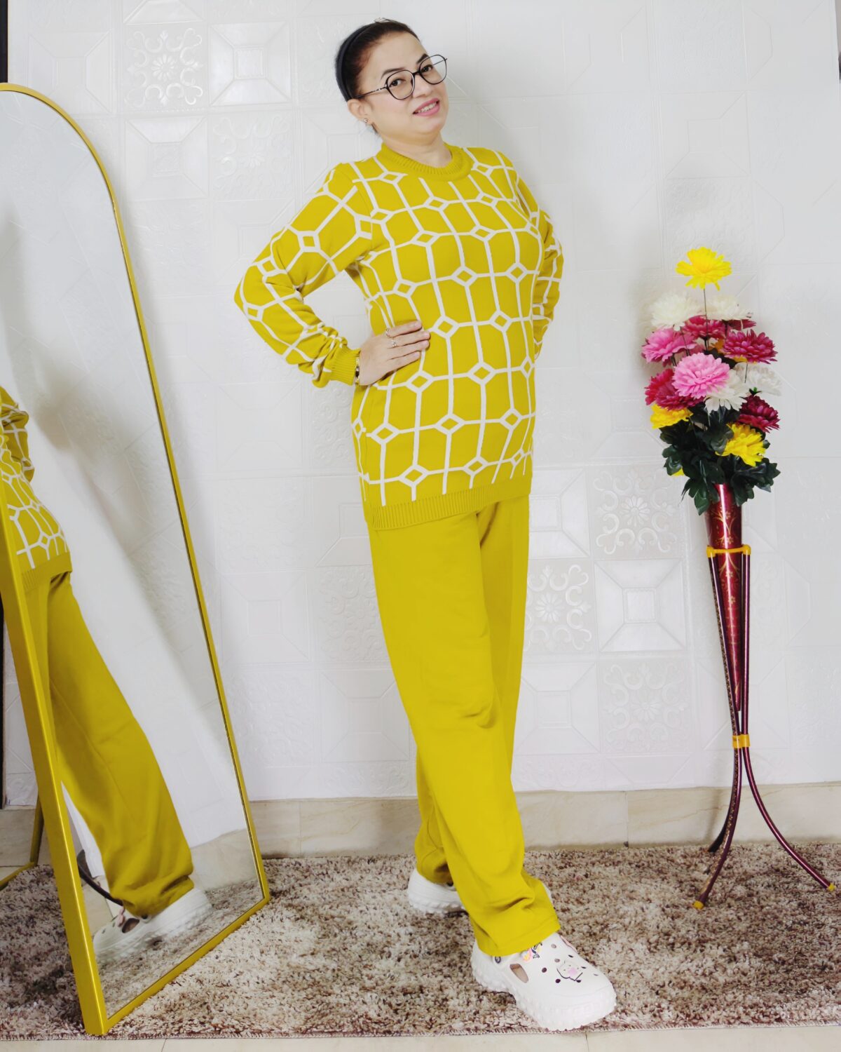 Woman wearing a black and white premium knitted co-ord set with a geometric patterned top and solid black pants