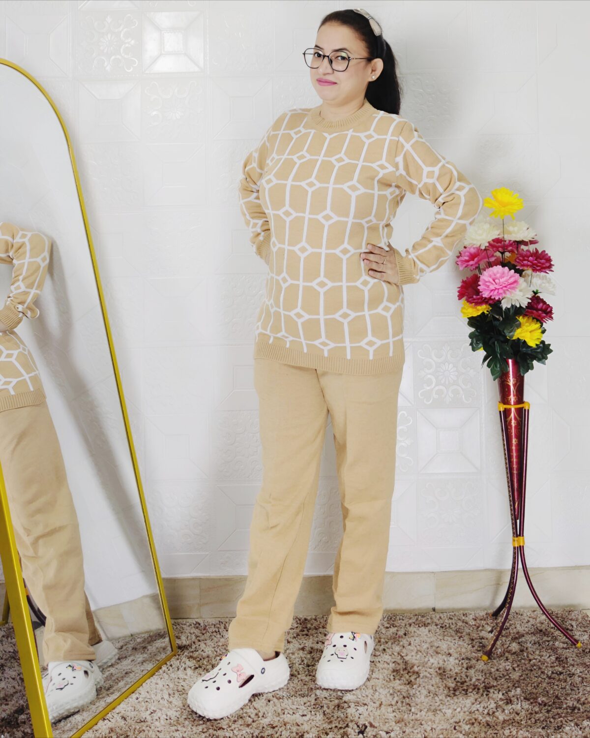 Woman wearing a black and white premium knitted co-ord set with a geometric patterned top and solid black pants