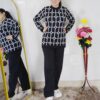 Woman wearing a black and white premium knitted co-ord set with a geometric patterned top and solid black pants