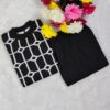 Woman wearing a black and white premium knitted co-ord set with a geometric patterned top and solid black pants