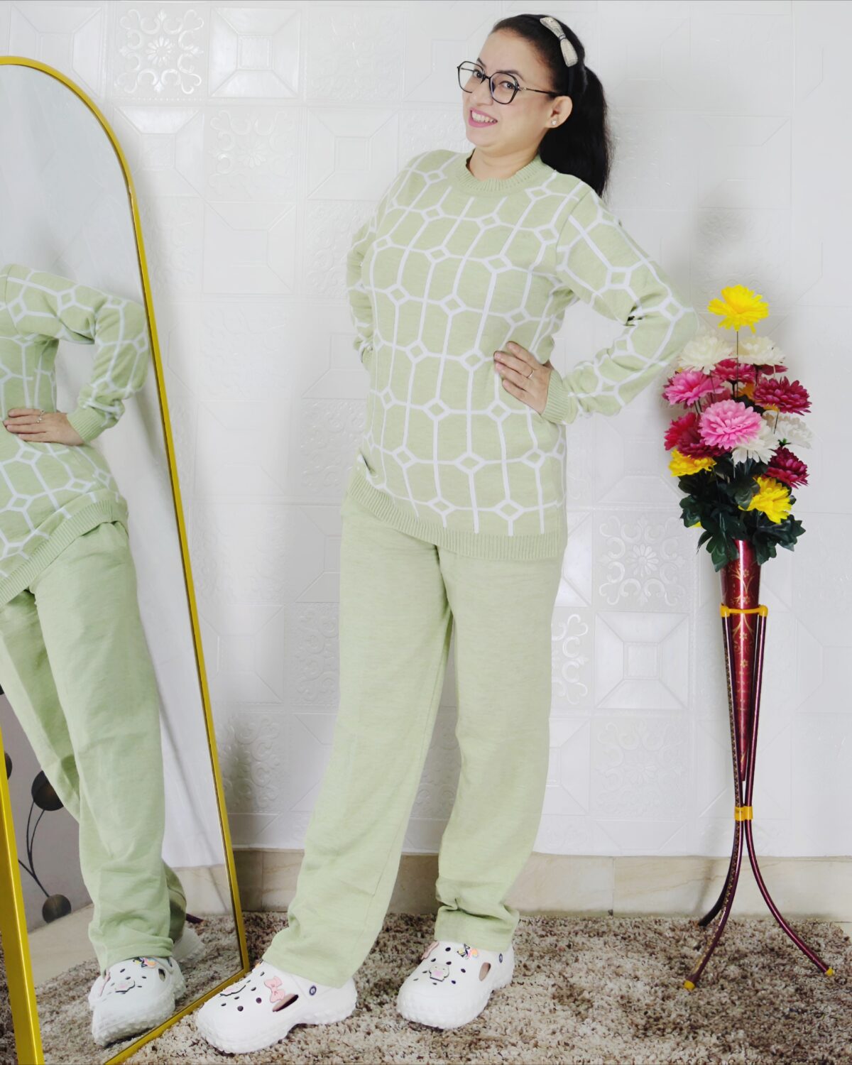 Woman wearing a black and white premium knitted co-ord set with a geometric patterned top and solid black pants
