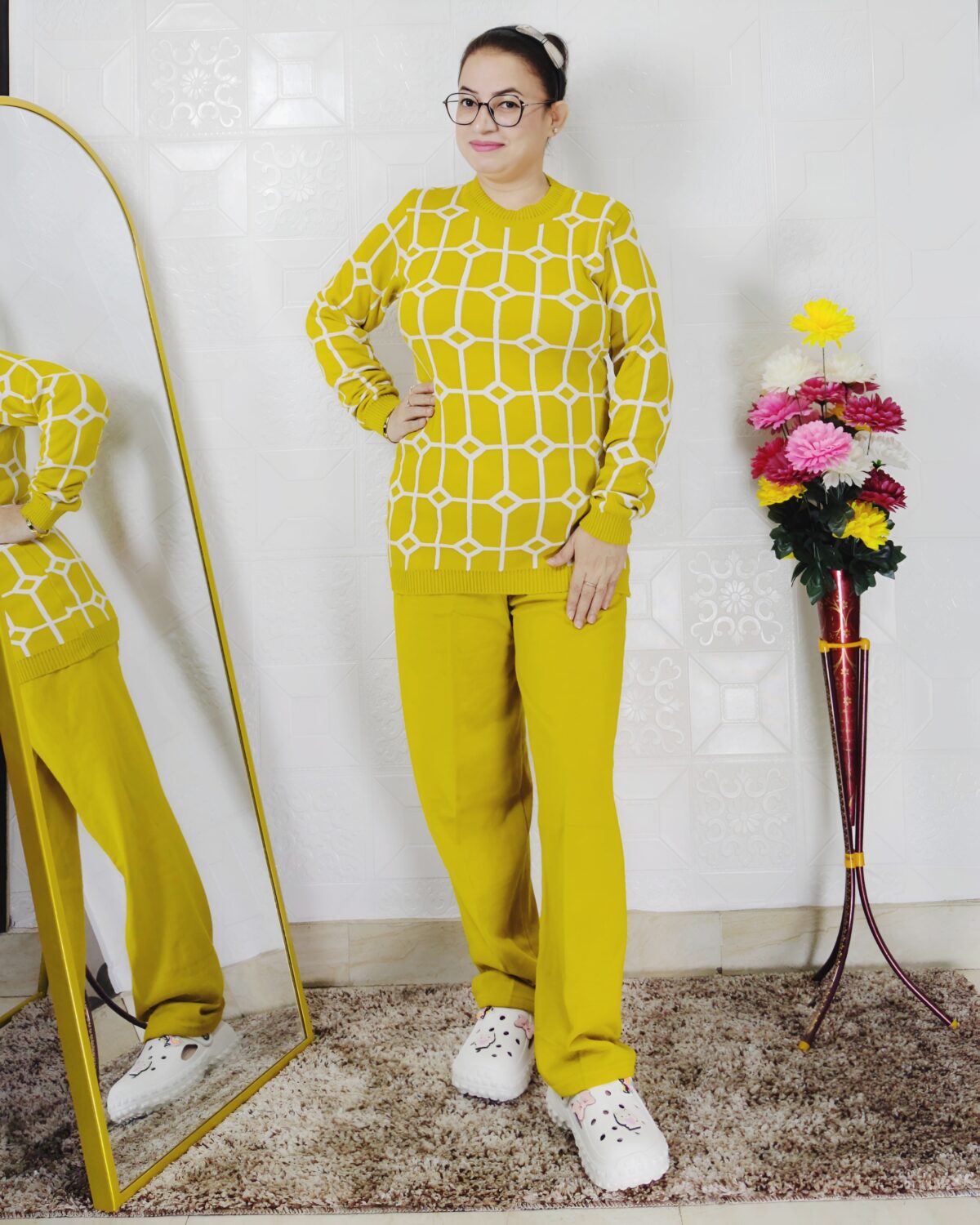 Woman wearing a black and white premium knitted co-ord set with a geometric patterned top and solid black pants