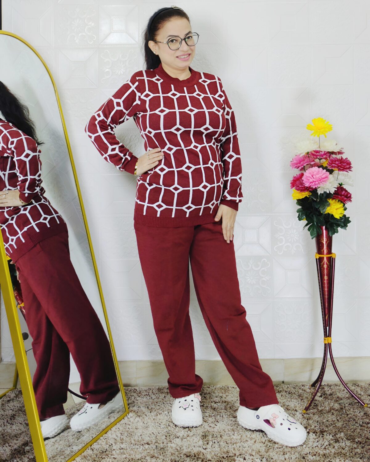 Woman wearing a black and white premium knitted co-ord set with a geometric patterned top and solid black pants