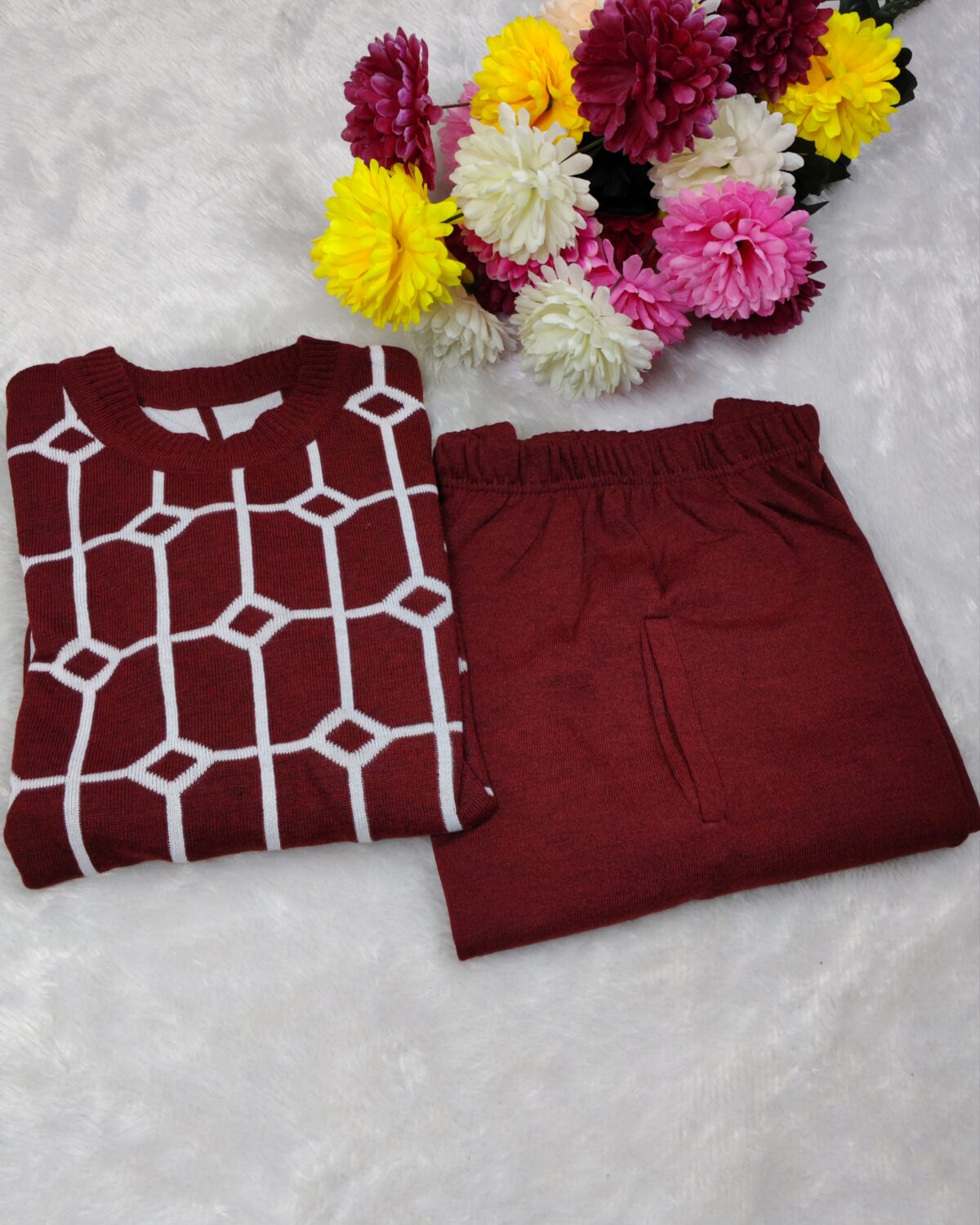 Woman wearing a black and white premium knitted co-ord set with a geometric patterned top and solid black pants