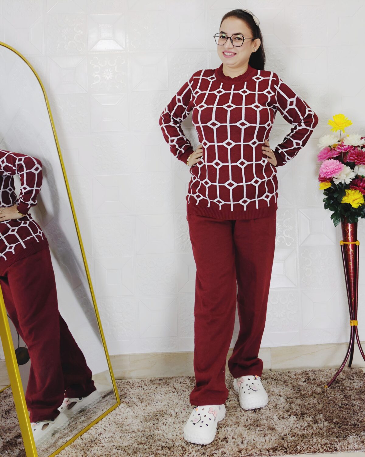 Woman wearing a black and white premium knitted co-ord set with a geometric patterned top and solid black pants
