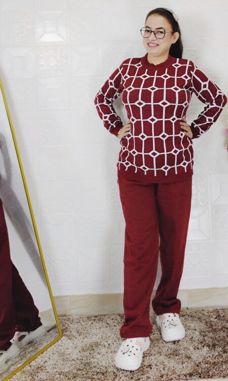 Woman wearing a black and white premium knitted co-ord set with a geometric patterned top and solid black pants