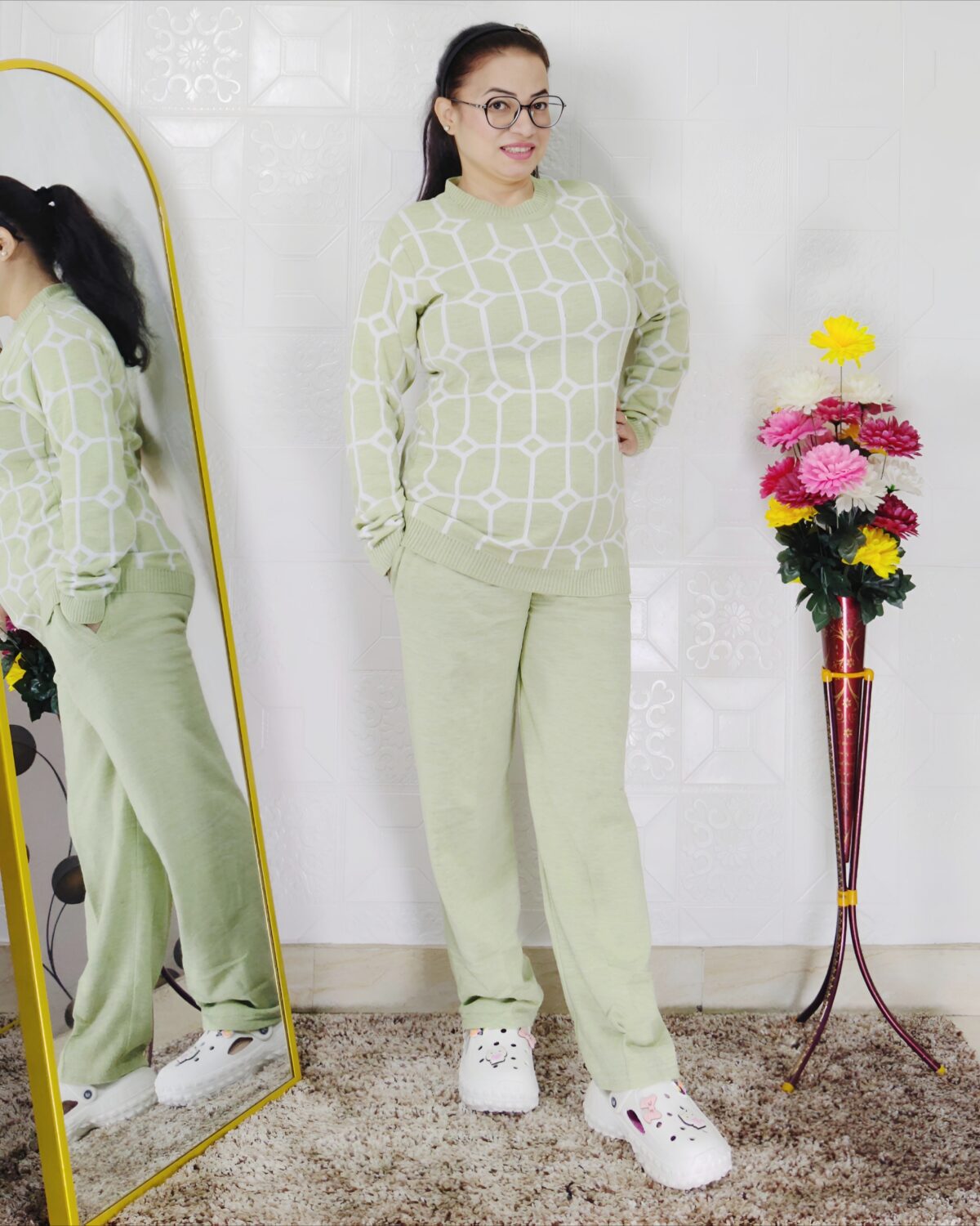 Woman wearing a black and white premium knitted co-ord set with a geometric patterned top and solid black pants
