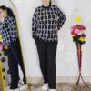 Woman wearing a black and white premium knitted co-ord set with a geometric patterned top and solid black pants