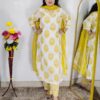 Woman wearing Off White and Yellow Printed Premium Cotton Straight Kurta Suit Set with Inner Lining, Matching Pants and Dupatta