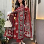 Woman wearing Rust Premium Cotton Printed Straight Kurta Suit Set with Matching Pants and Printed Dupatta